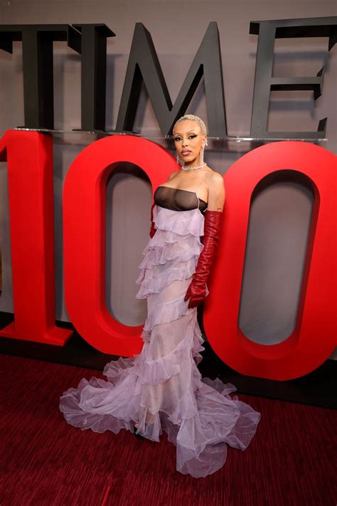 Doja Cat bares her incredibly toned midriff in a sheer nude dress